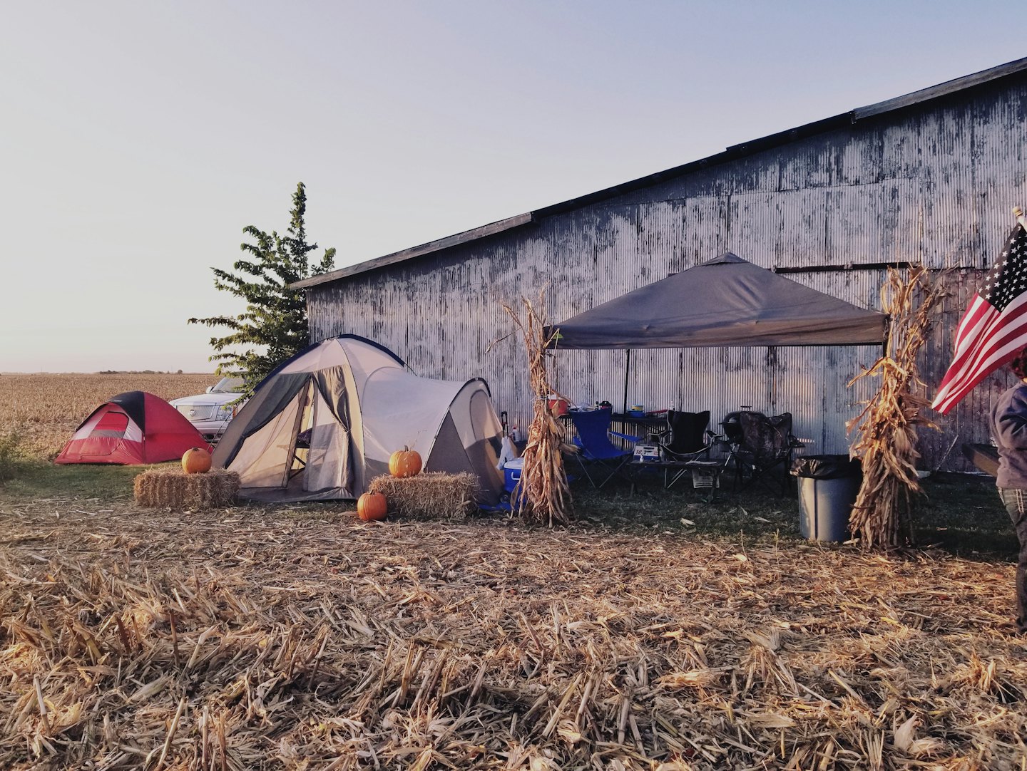 Tents and fall decorations sit near a barn and truck.